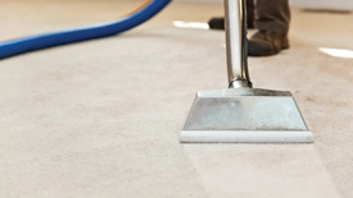 Carpet cleaning wand head gliding over a light carpet during hot-water extraction, Providence, RI.